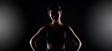 Genç sporcu olan Siyah Kemer Tekvando Karate Kız geleneksel dövüş pozlarını spor elbisesi, siyah arka plan izole, fotokopi alanı düşük karanlık pozlar