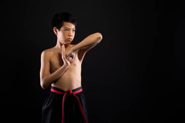 Usta Kırmızı Kemerli Tekvando Karateci genç sporcu. Spor elbisesiyle geleneksel dövüş pozları veriyor. Siyah arka plan izole edilmiş kopya alanı.