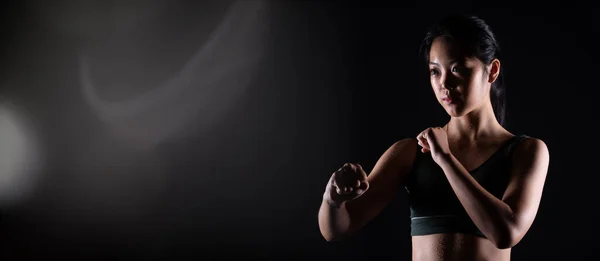 Master Black Belt TaeKwonDo Karate girl who is athlete young teenager show traditional Fighting poses in sport dress, black background isolated, copy space low dark exposure