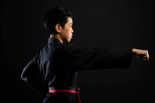 红黑带跆拳道空手道少年运动员的传统格斗姿势是穿着运动服 黑色背景是孤立的复制空间 — 图库照片