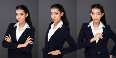 20 'li yaşlardaki Asyalı kadın portresinin yarısı siyah saçlı, pantolon giyiyor. Ofisteki kadın yüz ifadeleri ve gri arkaplanda izole edilmiş kameraya bakıyorlar.