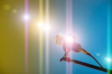 Mikrofon kondansatöründen güç sesi geliyor. Sarı mavi arkaplan stüdyo odası kopyalama alanı