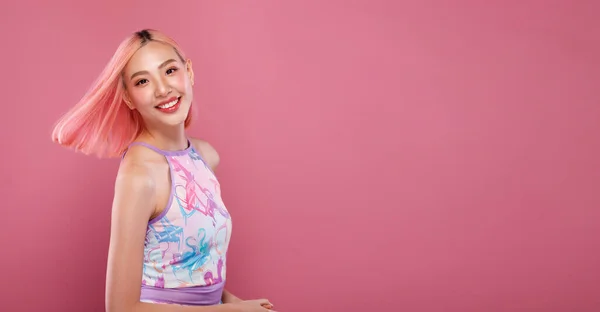 ハーフボディ20代のアジアの女性の肖像ピンク死ぬ髪フィットネススポーツヨガの服 女の子スロー髪で空気と笑顔上のピンクの汗背景隔離されたコピースペース — ストック写真