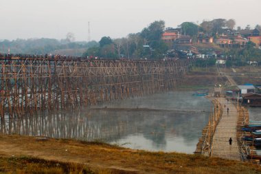 Sangklaburi ya da Myanmar yüksek ahşap köprüsü Songaria Nehri üzerinde, güzel manzaralı ve yerel geleneksel kültüre sahip bir uluslararası turizm merkezi. Wood Köprüsü 'nün mimarisi iki dünyayı birbirine bağlıyor.