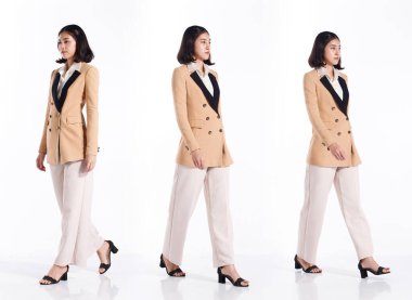 Kolaj Grubu 20 'li yaşlarda Asyalı bir kadının tam boy resmi kısa saçlı resmi takım elbise ve ayakkabılar. Ofisteki kız, beyaz arka planda iş adamı gibi tek başına yürüyor.