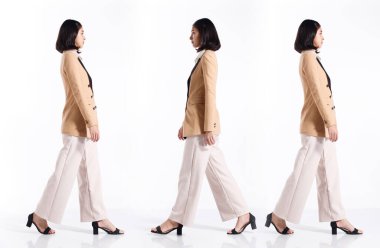 Kolaj Grubu 20 'li yaşlarda Asyalı bir kadının tam boy resmi kısa saçlı resmi takım elbise ve ayakkabılar. Ofisteki kız, beyaz arka planda iş adamı gibi tek başına yürüyor.