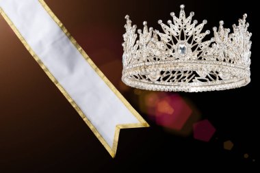 Bayan Güzellik Kraliçesi Güzellik Yarışması Galibi ödülünün sahibi Sash, Diamond Crown, stüdyo aydınlatma soyut koyu renkli tekstil arka planı.