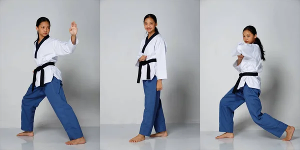 空手Taekwondoティーンエイジャーの女の子の練習黒帯のレベルで戦うPoomsaeとパンチ アジア青少年アスリートの女性は 完全な長さが隔離された白い背景に伝統的な制服を着用 — ストック写真