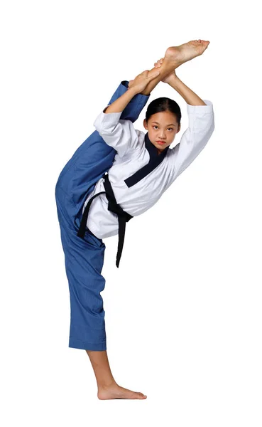 空手Taekwondoティーンエイジャーの女の子の練習格闘キックと黒帯のレベルで高い脚 アジア青少年アスリートの女性は 完全な長さが隔離された白い背景に伝統的な制服を着用 — ストック写真
