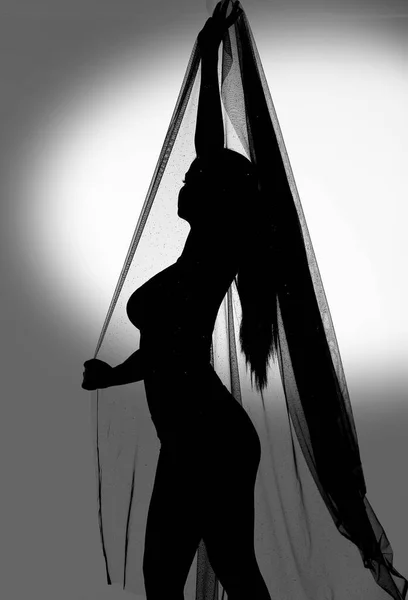 검은색으로 천으로 두르고 춤추고 반쯤되는 실루엣으로 고립된 스튜디오에서 몸매를 공중으로 — 스톡 사진