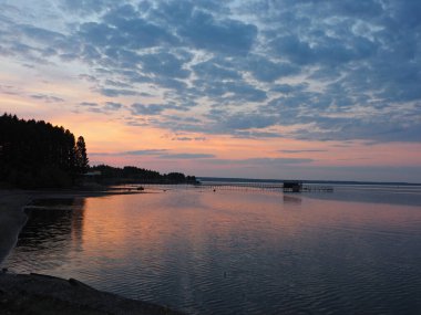 Gün batımı, yaz, gün batımında güzel bulutlar. Gök gürültülü günbatımı. Büyük Kama nehrindeki iskele. Ural, Rusya, Perma Bölgesi, Elovo.