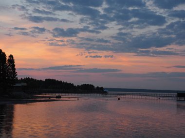 Gün batımı, yaz, gün batımında güzel bulutlar. Gök gürültülü günbatımı. Büyük Kama nehrindeki iskele. Ural, Rusya, Perma Bölgesi, Elovo.