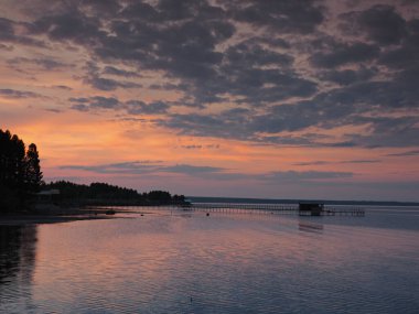 Gün batımı, yaz, gün batımında güzel bulutlar. Gök gürültülü günbatımı. Büyük Kama nehrindeki iskele. Ural, Rusya, Perma Bölgesi, Elovo.