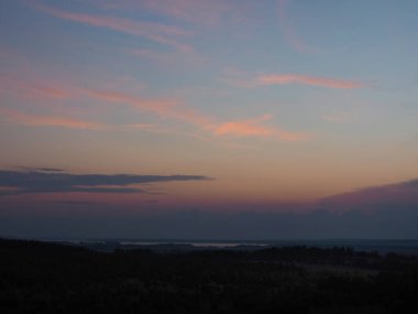 Gün batımından sonra güzel bir gökyüzü. Ural dağlarının tepeleri büyüyor, Kama nehri görülebilir durumda. Rusya, Perma Bölgesi, Elovo