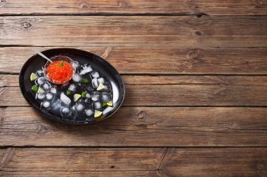 Siyah tabakta buz olan kırmızı bir Carviar.