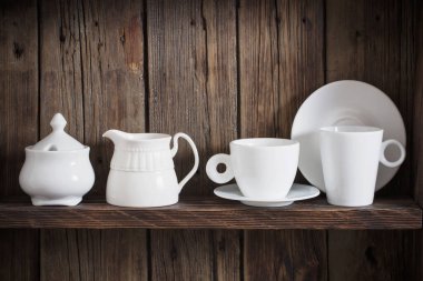 Eski siyah ahşap arka planda beyaz mutfak bulaşık takımı