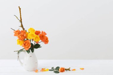 Beyaz arkaplanda beyaz sürahide güller