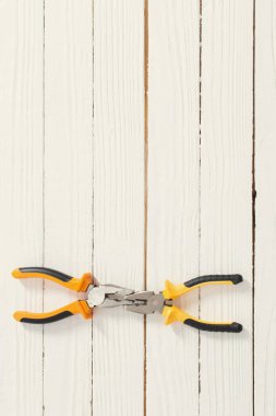 Beyaz ahşap arka planda pense