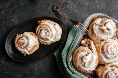 Tarçınlı çörek, koyu arkaplanda vanilyalı şekerleme..
