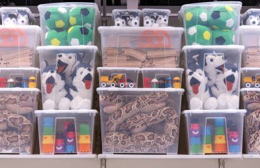 Çeşitli çocuk oyuncakları olan şeffaf plastik kaplar..