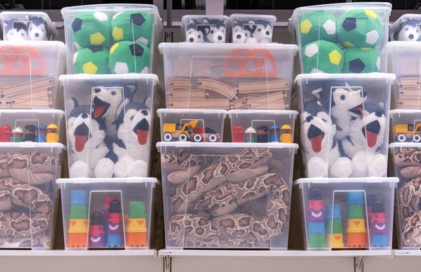 Çeşitli çocuk oyuncakları olan şeffaf plastik kaplar..