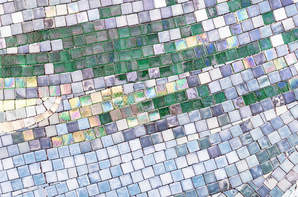 Керамическая мозаика с серыми, синими и зелеными квадратами, выложенными хаотично.