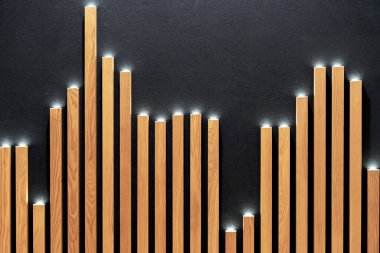 Dekoratif ahşap kaplamalı LED spot ışıkları siyah bir duvarda..