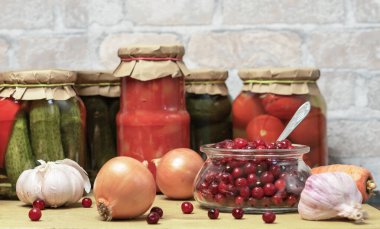 Kızılcık, sebze ve kavanoz dolusu domates ve salatalık. Kış için konserve sebze konservesi kavramı.