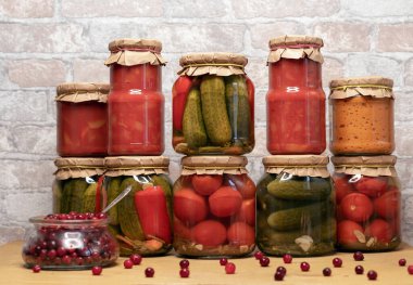 Kızılcık ve kavanoz dolusu domates ve salatalık. Kış için konserve sebze konservesi kavramı.