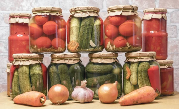 Pickled tomatoes, canned cucumbers and lecho in glass jars. Concept of home canning vegetables for the winter.