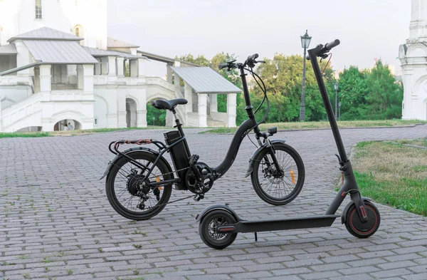 Eski bir binanın arka planında elektrikli bisiklet ve elektrikli scooter..