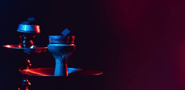 Modern nargile, siyah arka planda siyah ışık ve dumanlı bir shisha. Metnin için yakın plan ve yer