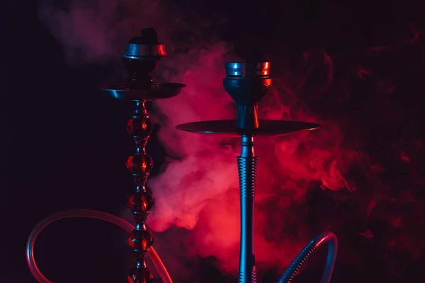 Hookah bowl, shisha and coals on a smoky black background with colored lighting — Stock Photo, Image