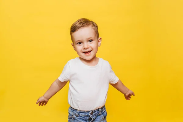 Un niño riéndose sobre un fondo amarillo. Copiar espacio. — Foto de Stock