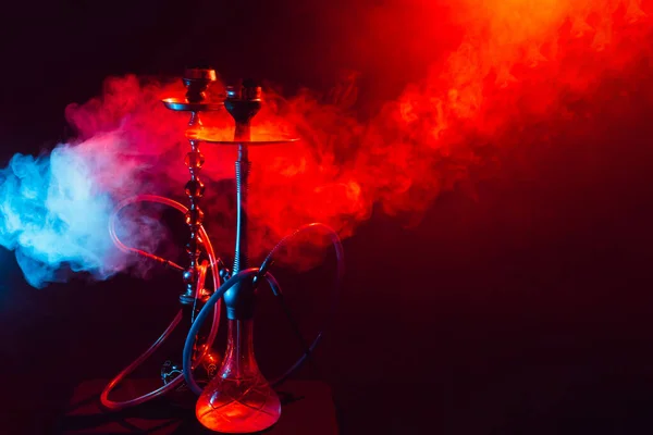 Hookah, shisha na dymiącym czarnym tle z neonowym oświetleniem i dymem. Miejsce na tekst — Zdjęcie stockowe