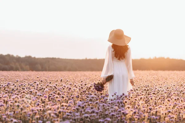 ラベンダー畑の美しい女の子。白いドレスに花束を手にした美しい女性. — ストック写真