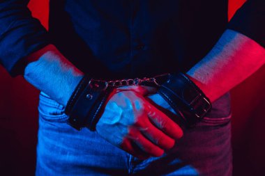 Erkeklerin elleri DDSM seksi için deri kelepçeli. Teslimiyet ve hakimiyet