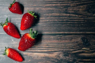 Koyu ahşap arka planda olgun çilek. Metnin için boşluk