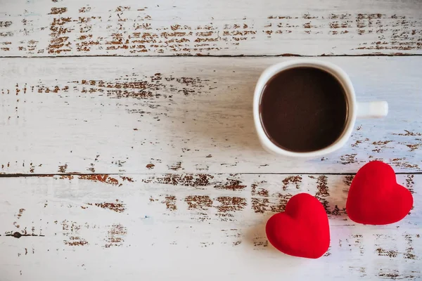 Inimi roșii și o ceașcă de cafea pe un fundal alb din lemn . — Fotografie, imagine de stoc