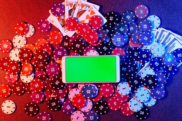 El concepto de un casino en línea: fichas de apuestas, dinero, naipes y un smartphone con espacio para copiar. Vista superior. — Foto de Stock