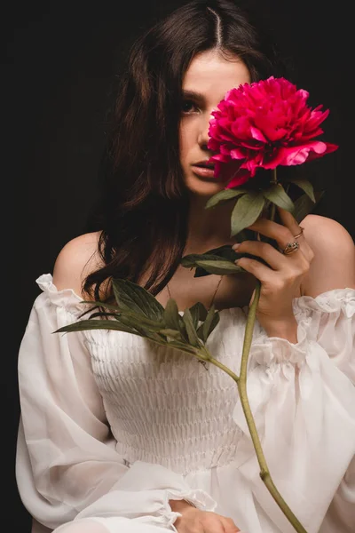Портрет молодої, красивої і чуттєвої жінки з 1 червоною квіткою півонії в руках — стокове фото