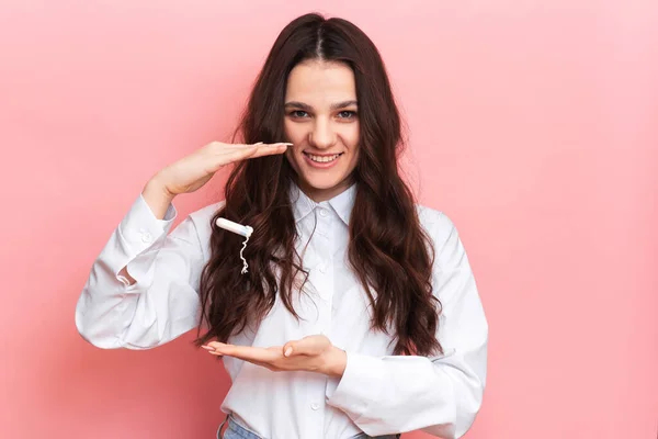 Eine Studioaufnahme eines Mädchens, das in einem Menstruationsapplikator einen Tampon in der Hand hält. Raum für den Text. Das Konzept der weiblichen Hygiene. — Stockfoto