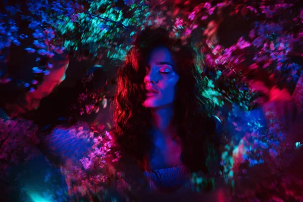 Çiçekli, neon renkli ve hayalperest bir kızın harika bir fotoğrafı. Fantezi konsepti, peri masalları, sihir ve periler.