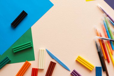 Çocukların yaratıcılığı ve gelişimi için bir set. Plastikler, keçeli kalemler, masaya renkli kağıtlar. Metnin için yer