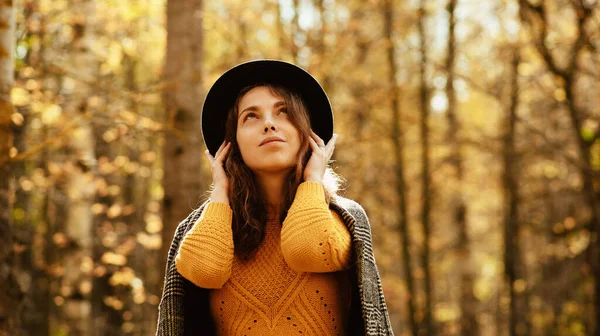 Portrait of a girl in a coat and hat on a background of foliage in an autumn Park — Stock Photo, Image