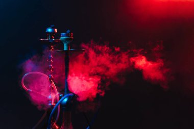 Modern nargile, dumanlı siyah arka planda, neon ışıklı ve dumanlı shisha. Metnin için yer