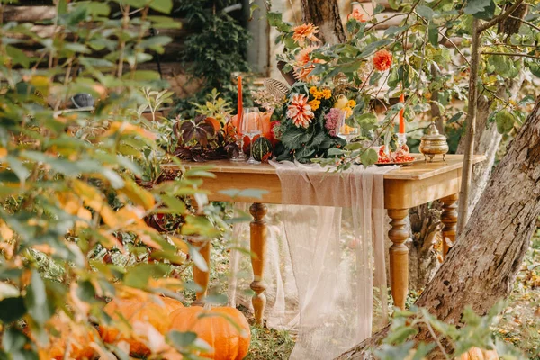 Осенняя романтическая обстановка: букет георгины, гранатов, свечей, тыкв и стаканов — стоковое фото