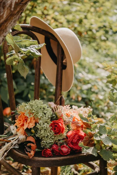Strauß Herbstblumen auf einem Stuhl im Freien liegend — Stockfoto