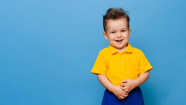 Pequenas caretas bonitos fica em um fundo azul. Miúdo engraçado. — Fotografia de Stock