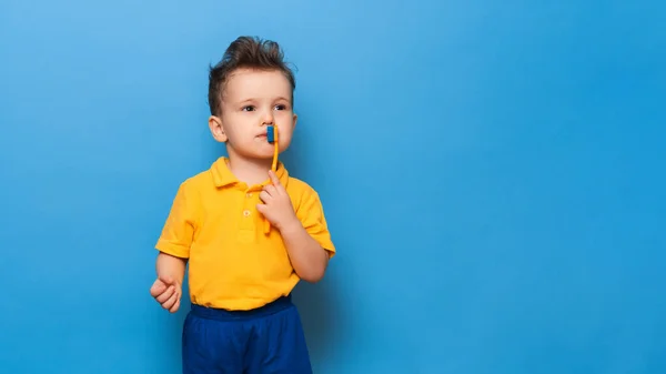 Criança feliz garoto escovar os dentes com escova de dentes no fundo azul. Saúde, higiene dentária. Mockup, espaço de cópia — Fotografia de Stock